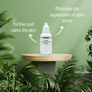 DMK Pore Reduction Drops Plus bottle on a wooden stand with greenery and product information