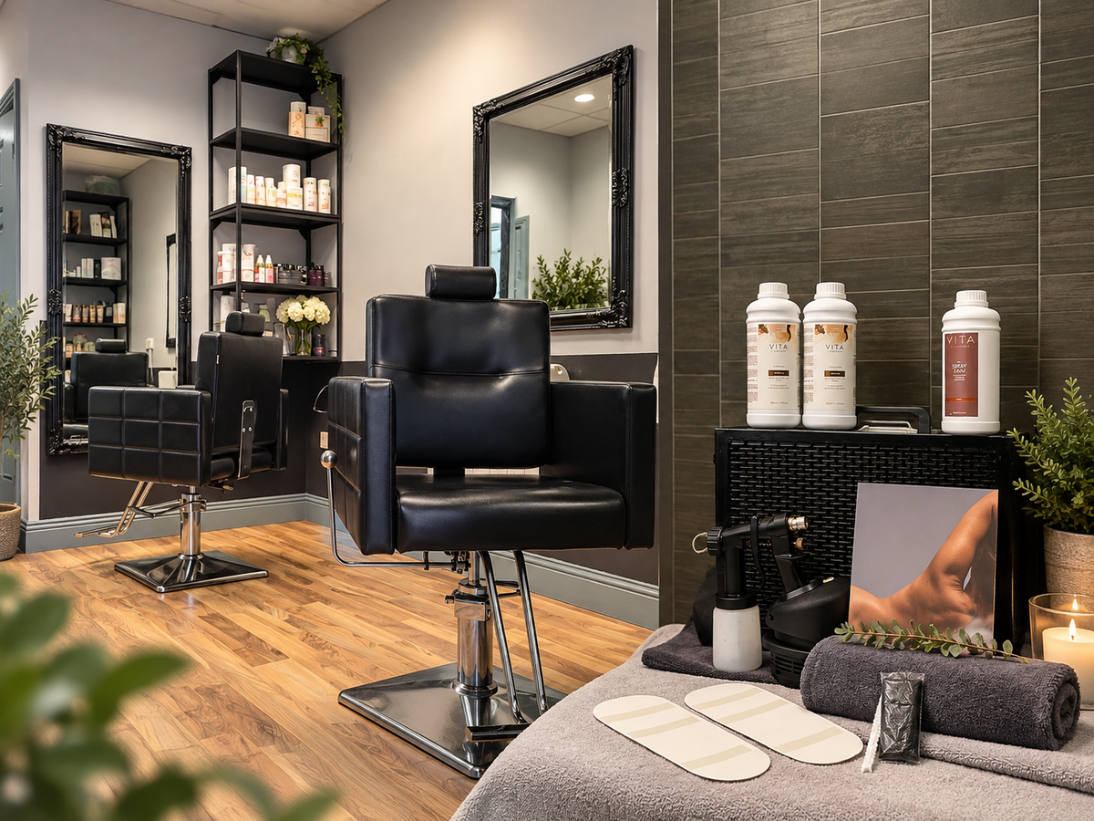 A modern  interior with a black leather barber chair centered in the foreground, wood floors, mirrors, shelving, and spa-style towels and bottles on a counter. No person is present, but this is still not a clean isolated product shot; it shows the product in a real environment, so subject_type is Lifestyle.