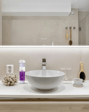Bathroom counter with a sink, toiletries, and decorative items. Cleansing Tonic Lotion