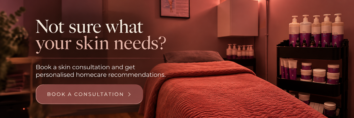 A warm-toned spa treatment room with a bed covered in a quilted coral-red blanket, shelves of skincare bottles, and overlaid text reading 'Not sure what your skin needs? Book a skin consultation and get personalised homecare recommendations.'.