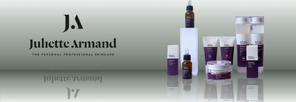 Juliette Armand skincare products on a reflective surface with a gradient background