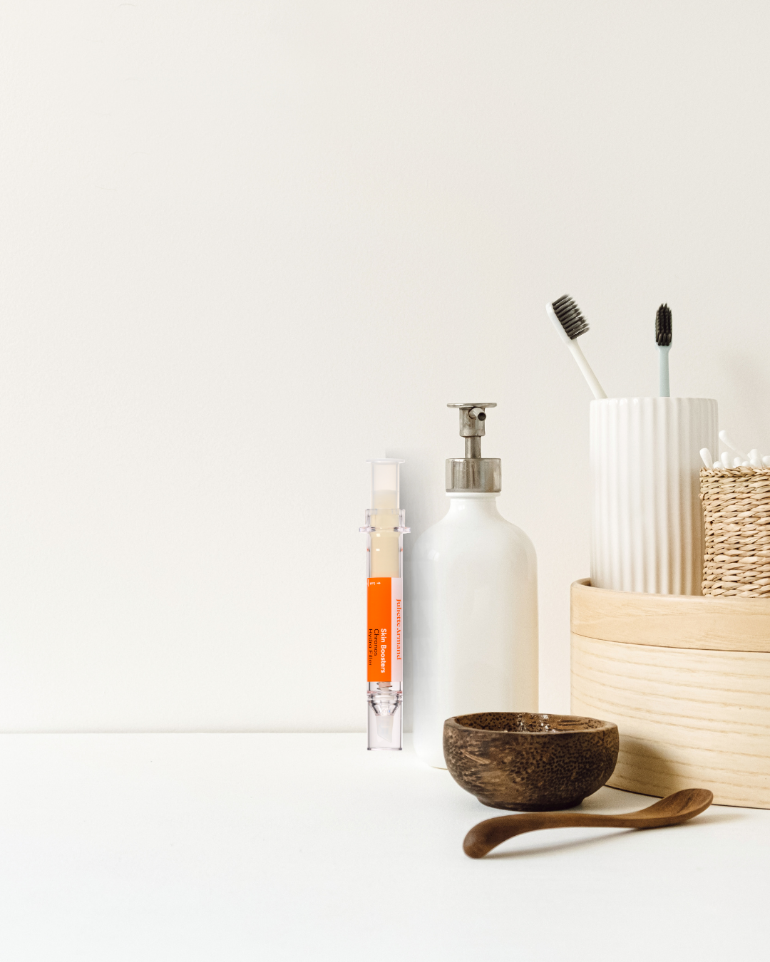 Bathroom essentials including a bottle, soap dispenser, and toothbrush holder on a white surface.