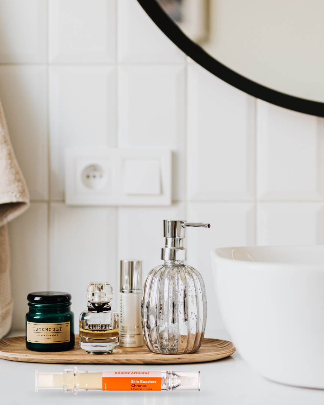 Bathroom counter with soap dispenser, candles, and a mirror.
